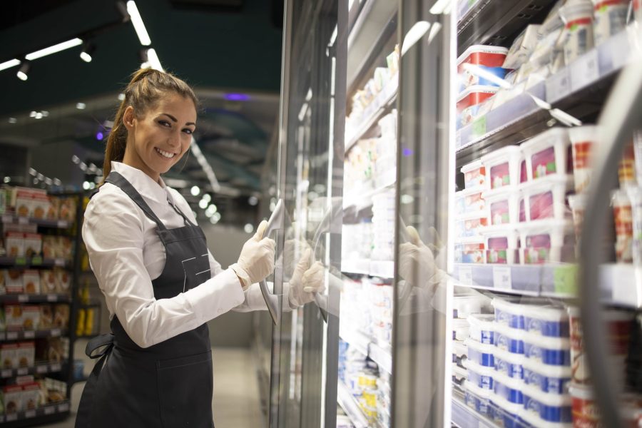 portrait-supermarket-worker-standing-by-freezer-with-food-min