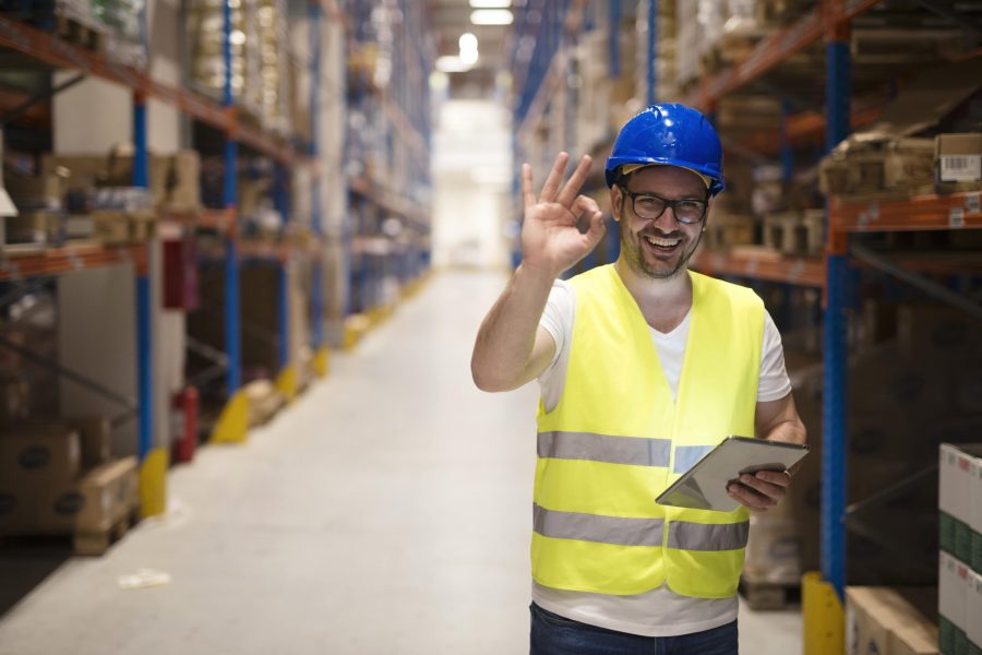warehouse-worker-standing-large-storage-center-showing-ok-hand-gesture-satisfied-delivering-goods-min
